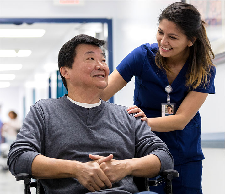 Женщина медицинский работник помогает мужчине в инвалидной коляске